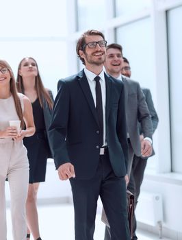 businessman walking in front of his business team . business concept