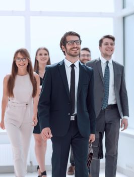 businessman walking in front of his business team . business concept