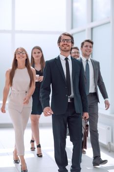 businessman walking in front of his business team . business concept