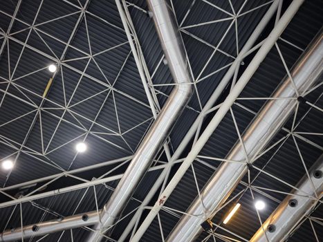 Wallpaper of the ceiling of a trade fair with tubes and lights forming geometric structures