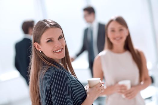 young businesswoman with a glass of coffee standing in the office . photo with space for text