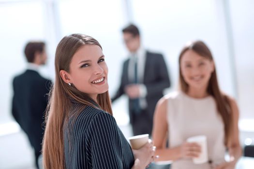 young businesswoman with a glass of coffee standing in the office . photo with space for text