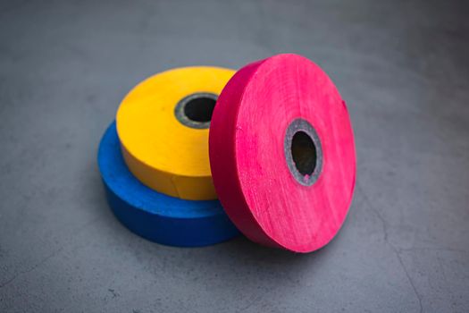 Three rolls of insulating tape on a dark background for use in construction and repair