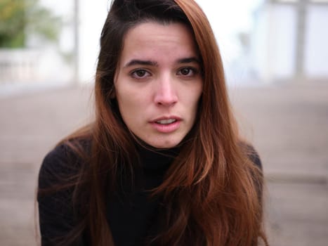 Portrait of a sad young girl looking at the camera crying with an out of focus background. Concept of emotions.