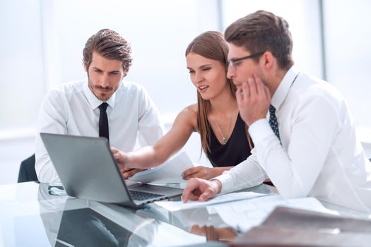 young employees discussing online news at a meeting in the office.