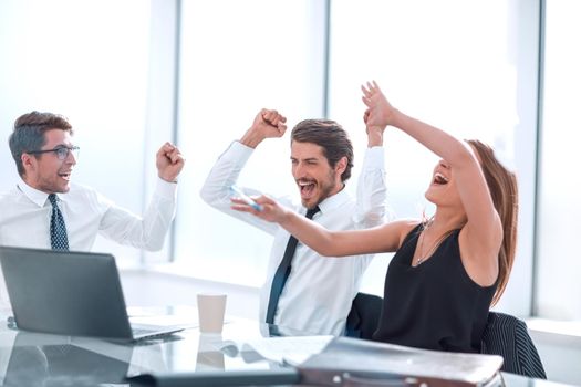 happy business team sitting at office Desk . the concept of success