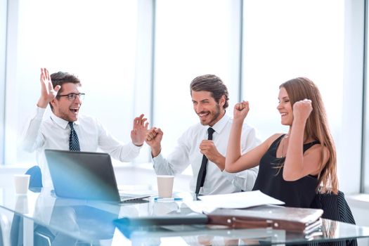 happy business team sitting at office Desk . the concept of success