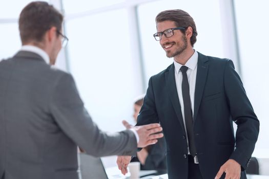 smiling business people holding out their hands for a handshake.concept of cooperation