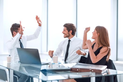 happy business team sitting at office Desk . the concept of success