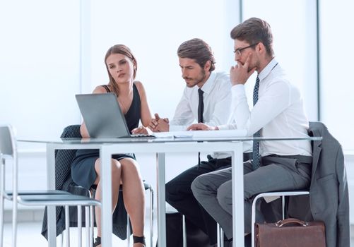 serious employees browsing online information on a laptop. photo with copy space