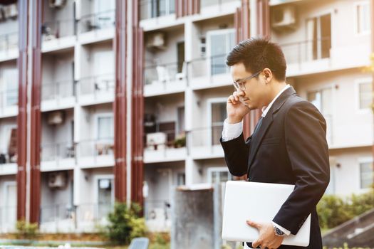 Concept Business - Handsome asian Business man working on property investment with laptop.