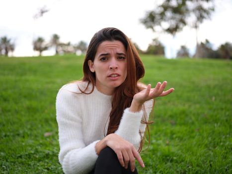 Front view of a portrait of an upset woman raising an eyebrow and her hand. Concept of emotions.