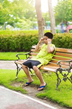 Sport concept - Little sport runner boy sit on the track and take a deep breath. Feel tired and bored.