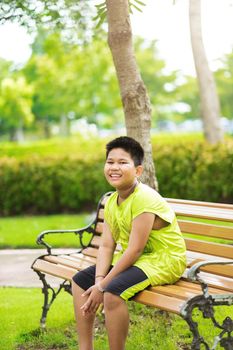 Asain cute little boy sitting with green nature.