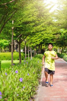 Asian man jogging at the park in sunny morning