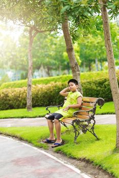 Sport concept - Little sport runner boy sit on the track and take a deep breath. Feel tired and bored.