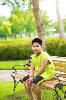 Asain cute little boy sitting with green nature.