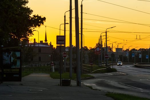 Riga, Latvia- July 17 2020: city street, bus station at sunrise time, electricity lines