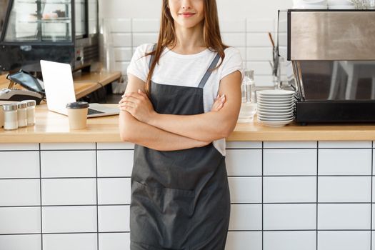 Coffee Business owner Concept - attractive young beautiful caucasian barista in apron smiling at camera in coffee shop counter.