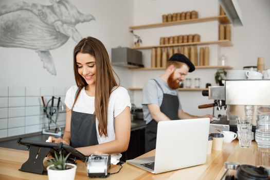 Coffee Business Concept - beautiful caucasian bartender barista or manager Posting order in digital tablet menu at modern coffee shop.