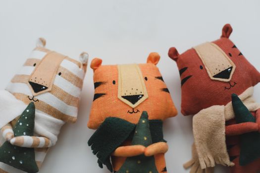 Handmade funny small tiger toys, symbol of new 2022 on white background. Crochet stuffed animals.