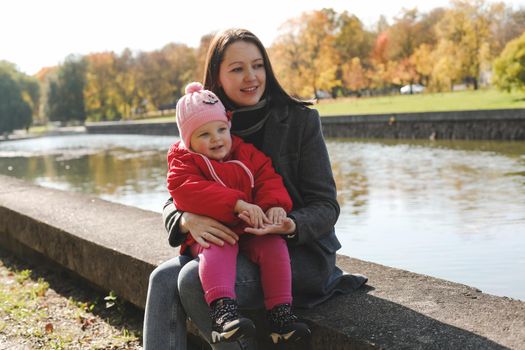 mom and child having fun and walking in the autumn park.