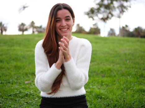 Front view of a happy young woman applauding to the camera. Concept of emotions.