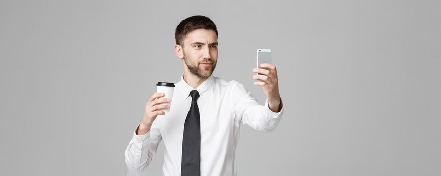 Lifestyle and Business Concept - Portrait of a handsome businessman enjoy taking a selfie with take away cup of coffee. Isolated White background. Copy Space.