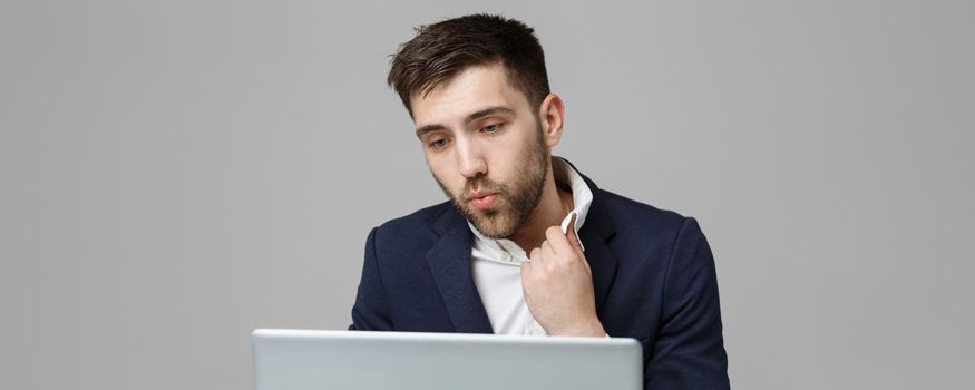 Business Concept - Portrait handsome stressful business man in suit shock looking at work in laptop. White Background.