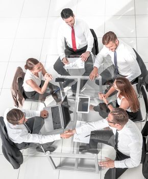 Office workers gather around a table to do research and implement new ideas.