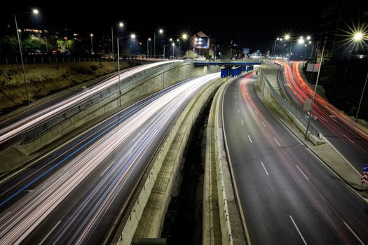 Night traffic junction road with lights of vehicle movement. Horizontal view