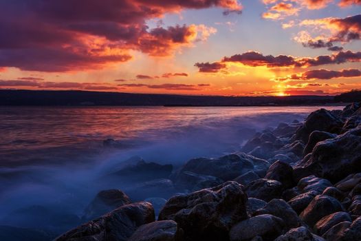 Sunning long exposure sunset over the sea with a rocky beach.