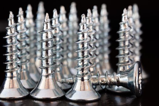 Close up of screws on a black background. Advertising photo