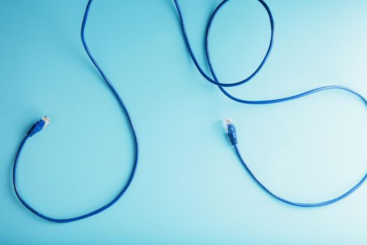 Blue Ethernet Cable Connectors Patch cord cord close-up isolated on a blue background with free space