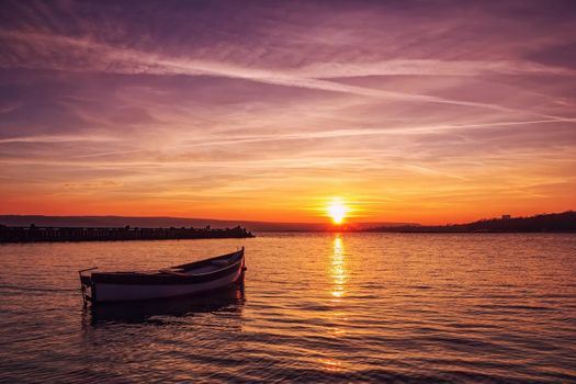 Beautiful light composition and mood of the boat in calm water at sunset