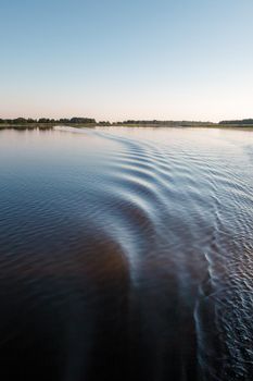 A very nice footprint of a ship's propeller in the lake water. Vertical photo