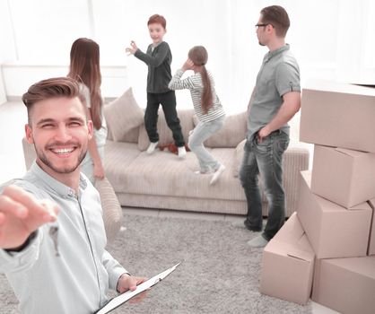 smiling realtor with clipboard showing keys to new apartment.mortgage, family and real estate concept