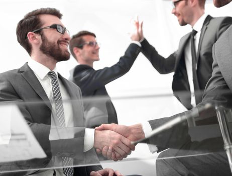 business handshake and business team giving each other high five .the concept of teamwork
