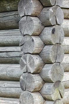 Background. Corner of blockhouse close up. A log wall of wooden house. Vertical photo.