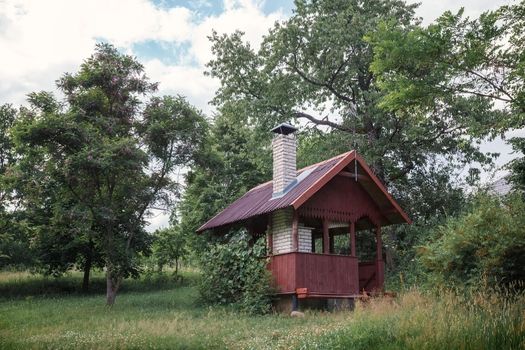 Gazebo for barbecue, pavilion and BBQ Oven in the autumn garden. Place to relax for families in the courtyard of the house. Orchard, apple tree.