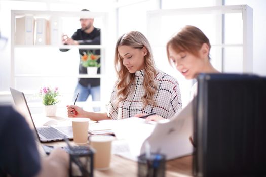 two young women sitting at the office table. office life