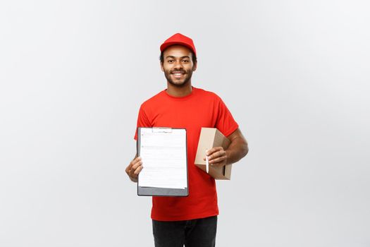 Delivery Concept - Portrait of Handsome African American delivery man or courier showing a confirmation document form to sign. Isolated on Grey studio Background. Copy Space