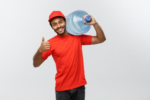 Delivery Concept - Handsome African American delivery man holding water tank. Isolated on Grey studio Background. Copy Space