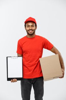 Delivery Concept - Portrait of Handsome African American delivery man or courier showing a confirmation document form to sign. Isolated on Grey studio Background. Copy Space