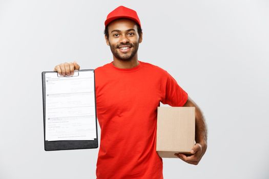 Delivery Concept - Portrait of Handsome African American delivery man or courier showing a confirmation document form to sign. Isolated on Grey studio Background. Copy Space