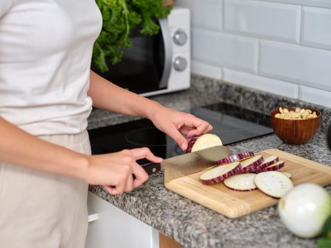 woman chopping the vegetables into slices to prepare a tabbouleh, horizontal cutout view