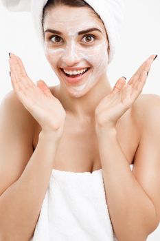 Beauty Skin Care Concept - Beautiful Caucasian Woman Face Portrait applying cream mask on her facial skin white background