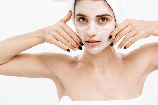 Beauty Skin Care Concept - Beautiful Caucasian Woman Face Portrait applying cream mask on her facial skin white background