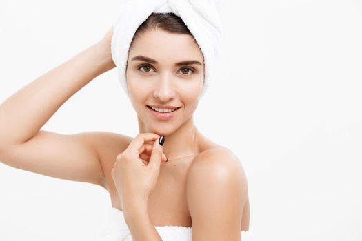 Beauty and Skin care concept - Beautiful caucasian Young Woman with bath towel on head covering her breasts, on white