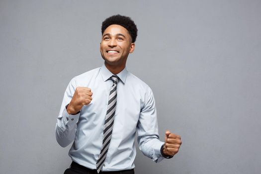 Business Concept - Confident happy young African American throwing fists in air celebrating for success projects